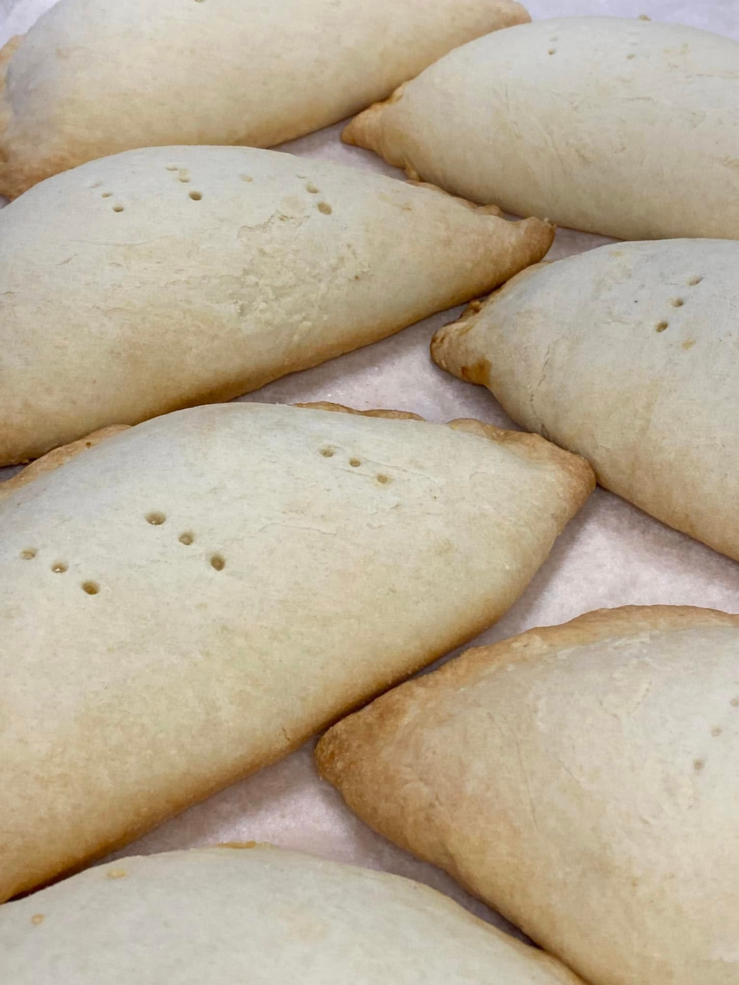 Golden baked hand pies fresh out of the oven on parchment