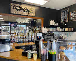 The espresso bar at Ini's Coffee — oak counter and syrup wall